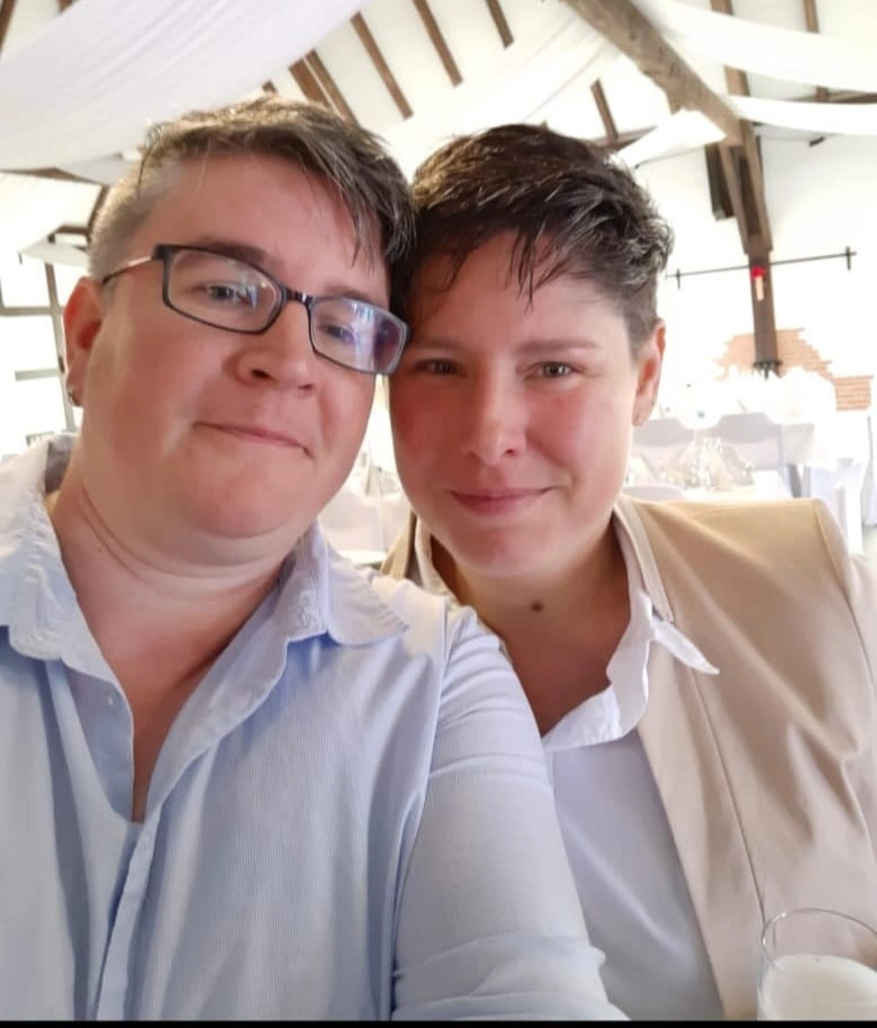 Pflegedienst Döring - Ambulanten Pflegedienstes - Ein Selfie aus nächster Nähe, das zwei lächelnde Personen bei einer Veranstaltung in geschlossenen Räumen zeigt; beide tragen Hemden mit Kragen und haben kurz gestylte Haare.